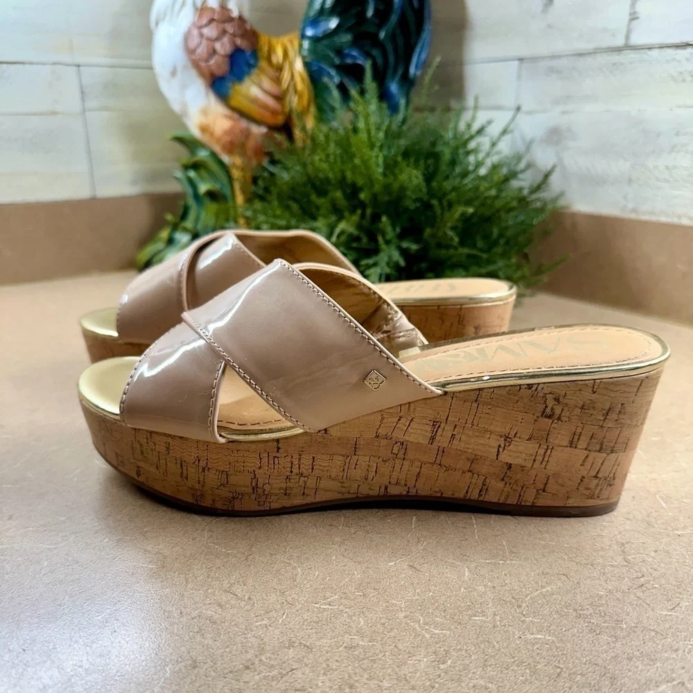 SAM&LIBBY, BEIGE PATENT,WEDGE SANDAL. CROSSOVER STRAPS ON A GOLDTRIMMED FOOTBED.